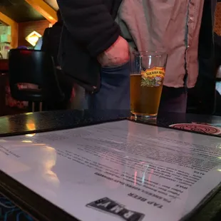 a menu and a glass of beer