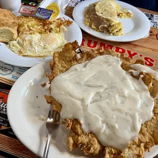 Hand Breaded Chicken Fried Steak and Eggs platter with hash browns and a biscuit