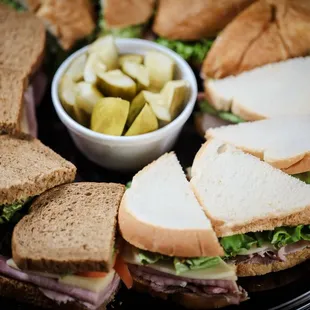 a platter of sandwiches and pickles