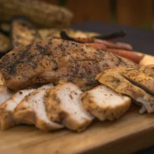 pork, carrots, and corn on a cutting board