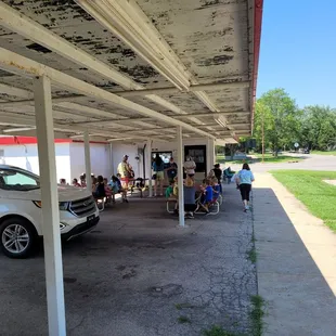 people sitting under a covered parking lot