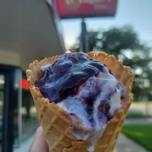 a hand holding an ice cream cone