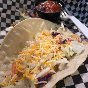 a taco with shredded cheese and lettuce