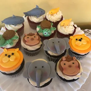 a plate of cupcakes decorated with animals