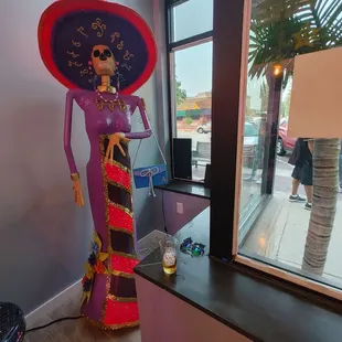  statue of a woman in a purple dress and large hat