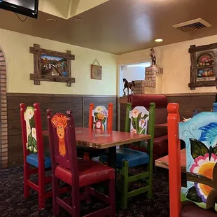 a dining area with colorful chairs and tables