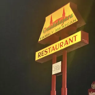 a restaurant sign lit up at night