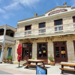 the outside of a restaurant with tables and umbrellas
