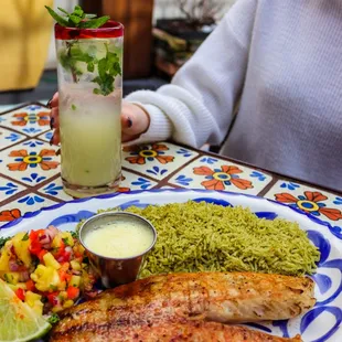 a woman sitting at a table with a plate of food