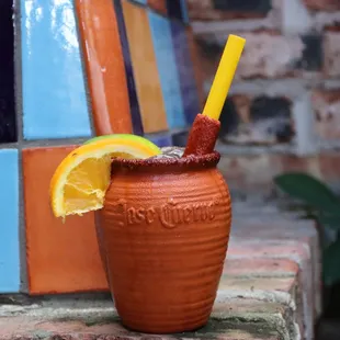 a drink with a straw and orange slice