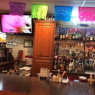a bar with mexican flags hanging from the ceiling