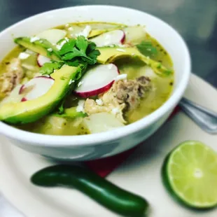 Posole Verde: a mild brothy stew simmered with chicken, made w/ green peppers and tomatillo. Mixed with chunks of potato and hominy kernels!