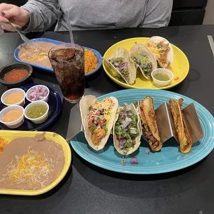 a table of tacos, rice, and salsa