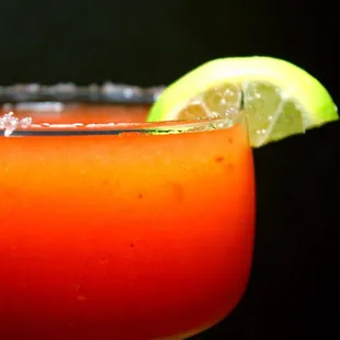 a closeup of a margarita with a lime wedge