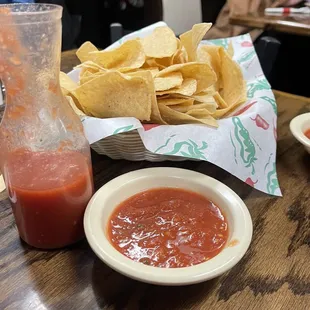 a table with chips, salsa and a bottle of ketchup