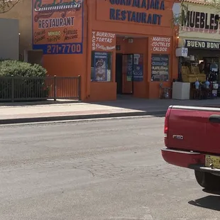 a red truck parked in front of a restaurant