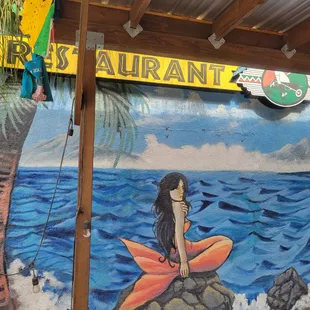 a mural of a woman sitting on a surfboard