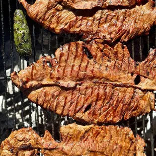 steaks being cooked on a grill