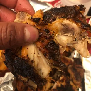 a hand holding a piece of pizza