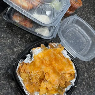 a plate of nachos and a container of nachos