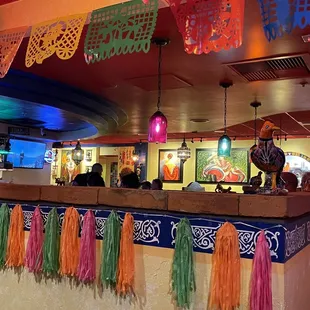 a mexican restaurant with colorful tassels hanging from the ceiling