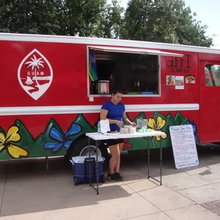 a woman sitting at a table in front of a food truck