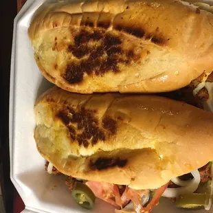 two sandwiches in a styrofoam container