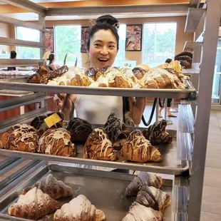 a woman holding a tray of pastries