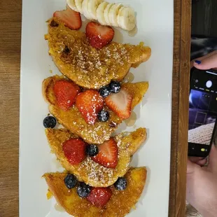 Crunchy French toast delicious with blueberries strawberries bananas powdered sugar