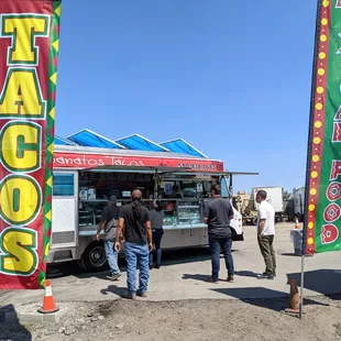 Truck located on large dirt lot with parking.