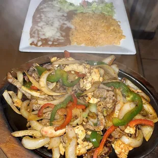 Fajitas mixed steak and chicken with a side of rice and beans
