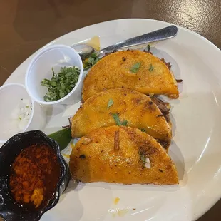 Quesabirria tacos and consume with cilantro and onions