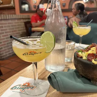 a bowl of guacamole and a glass of margarita