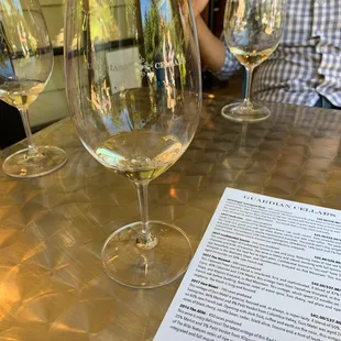 a man sitting at a table with wine glasses