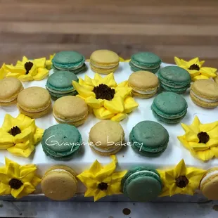a cake decorated with sunflowers and macarons