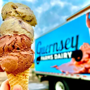 a hand holding a cone of ice cream