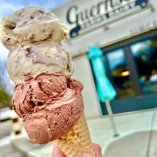 a hand holding a cone of ice cream