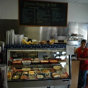 a woman standing in front of a deli counter