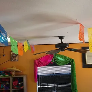a room with a ceiling fan and colorful decorations