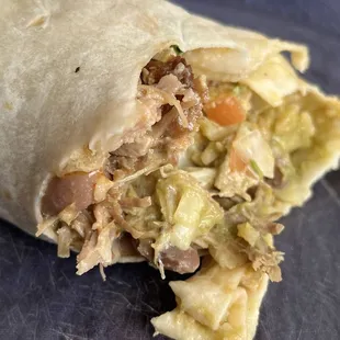 A bite out of a super baby burrito with beans.