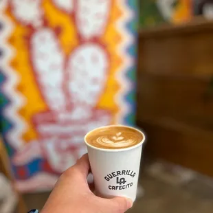 a hand holding a cup of coffee