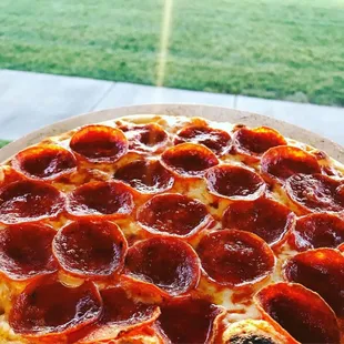 a pepperoni pizza on a pizza stone