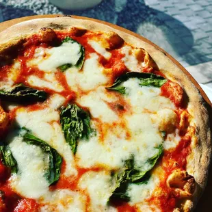 a pizza with cheese and spinach