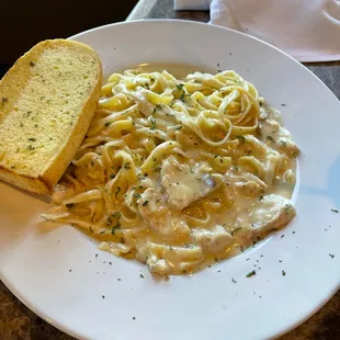 Homemade pasta fettuccine Alfredo with garlic bread.