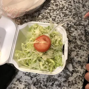 a salad in a styrofoam container
