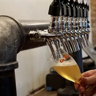 a person filling a glass of beer