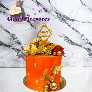 an orange cake with gold decorations