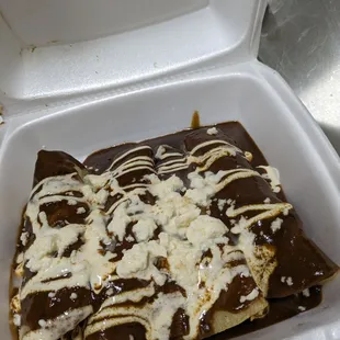 Chicken Mole Enchiladas topped with Mexican creme and fresh cheese