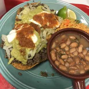 a plate of food with beans, rice, and guacamole