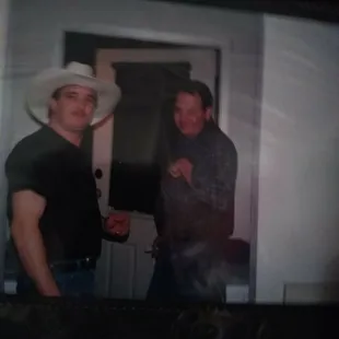 a man in a cowboy hat and a man in a black shirt